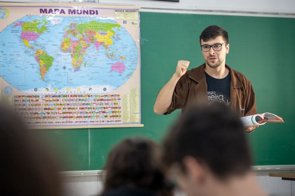 professor explicando o mapa mundi para ilustrar a educação ambiental nas aulas de inglês